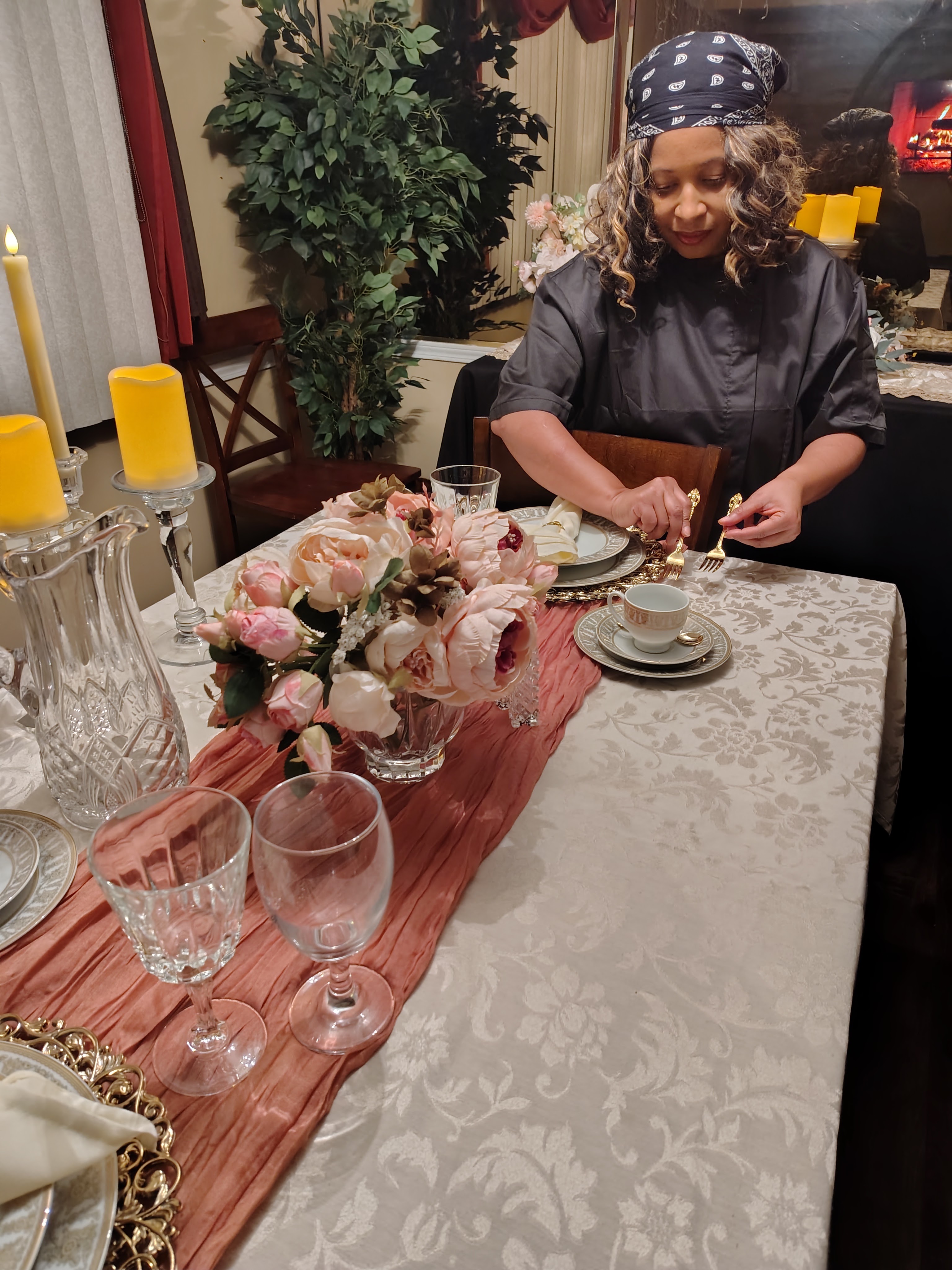 Chef Shorlanda setting an elegant table for two with roses and gold flatware