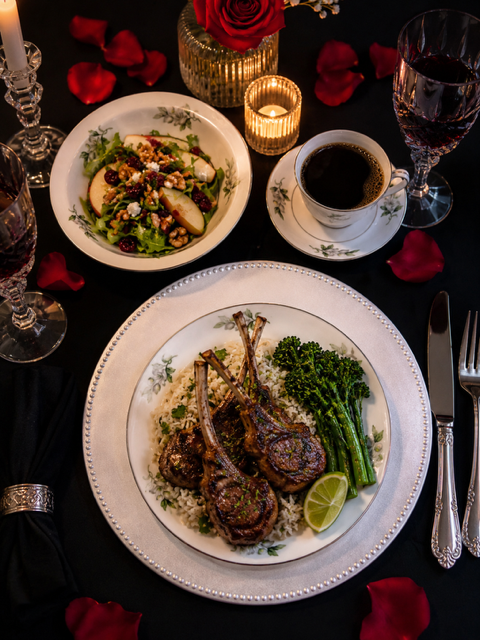 Herb-crusted pan seared lamb chops with rice, broccolini, and elegant table setting